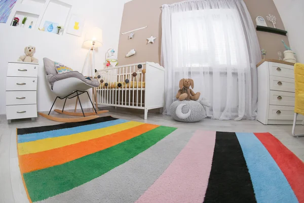 Затишний інтер'єр дитячої кімнати з ліжечком і кріслом для качання — стокове фото
