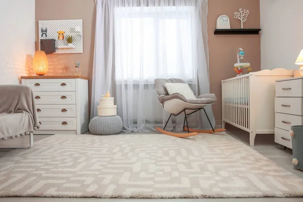 Acogedor interior de la habitación del bebé con cuna y mecedora —  Fotos de Stock