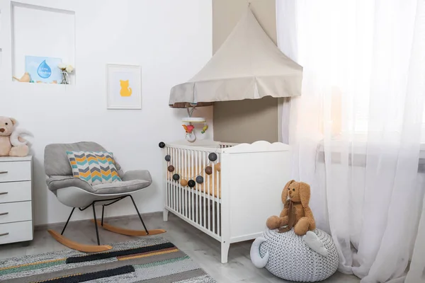 Cozy baby room interior with crib and rocking chair — Stock Photo, Image