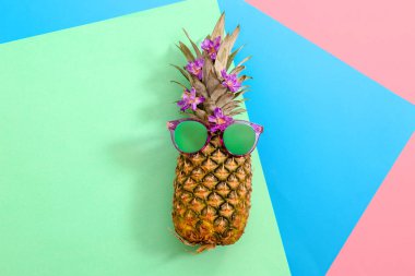 Renk arka plan, üstten görünüm üzerinde güneş gözlüklü olgun taze ananas