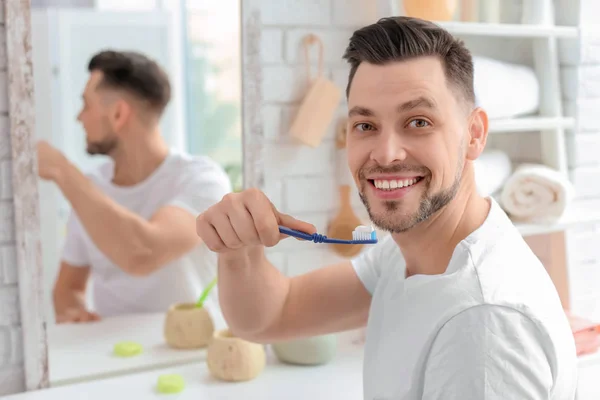 Молодий чоловік чистить зуби у ванній — стокове фото
