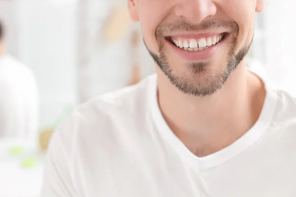 Un joven con una hermosa sonrisa en el interior. Blanqueamiento dental — Foto de Stock