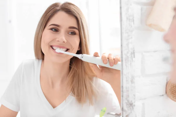 Ung kvinna borsta hennes tänder i badrum — Stockfoto