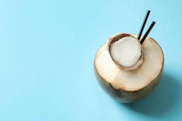 Fresh green coconut with drinking straws on color background — Stock Photo, Image