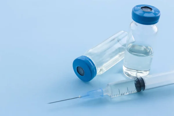 带疫苗和注射器的瓶子颜色背景 — 图库照片