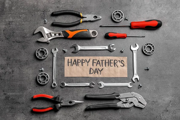 Verschillende instrumenten en kaart met woorden Happy Father'S Day op grijze achtergrond, bovenaanzicht — Stockfoto