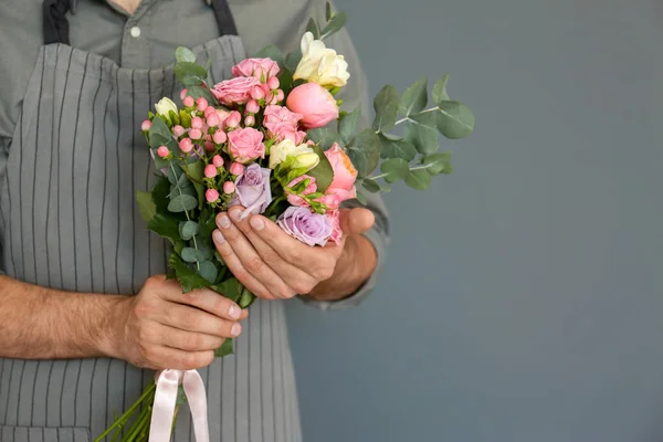 Manliga florist med vacker bukett på färgbakgrund — Stockfoto