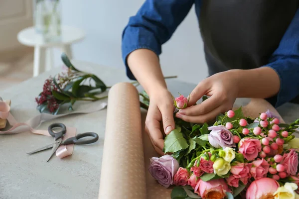 Female florist creating beautiful bouquet at table — Stock Photo, Image