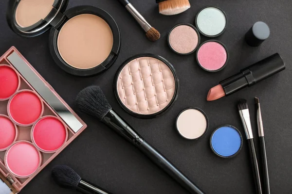 Plat lag samenstelling met make up borstels en cosmetische producten op zwarte achtergrond — Stockfoto