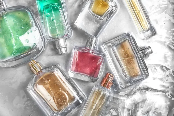 Различные духи бутылки в воде, плоский лежал — стоковое фото