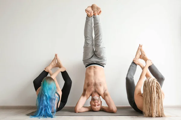 Grupo de personas que practican yoga en interiores — Foto de Stock