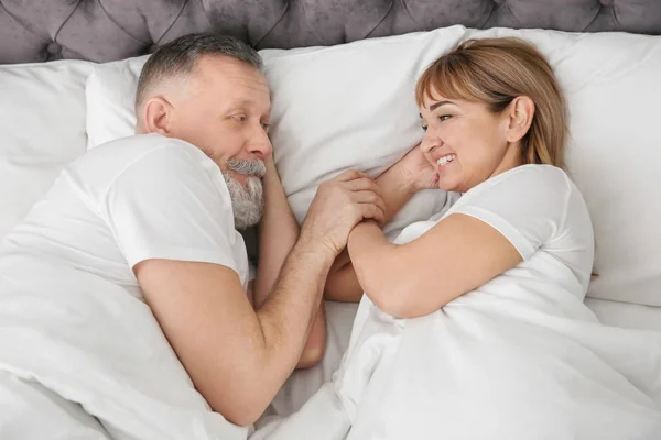 Зрелая пара вместе в постели дома — стоковое фото