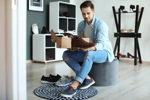 Joven hombre elegir zapatos en la tienda — Foto de Stock