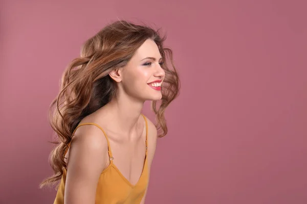 Portrait de jeune femme avec de longs beaux cheveux sur fond de couleur — Photo