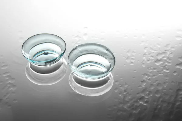 Lentes de contato no fundo de vidro molhado — Fotografia de Stock