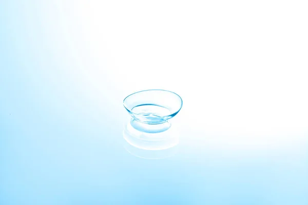 Contact lens on color glass background — Stock Photo, Image