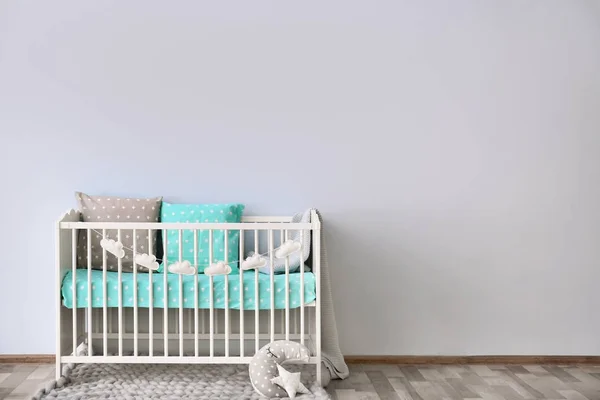 Интерьер детской комнаты с кроваткой у стены — стоковое фото