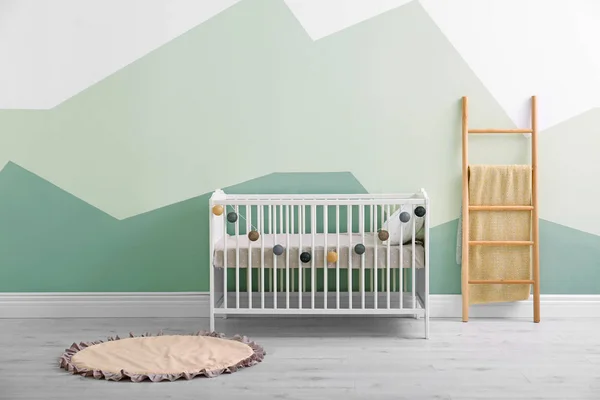 Baby room interior with crib near wall — Stock Photo, Image