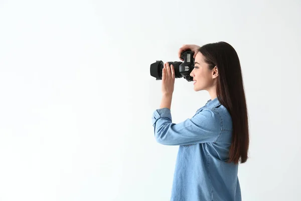 Fotografo femminile con macchina fotografica su sfondo chiaro — Foto Stock