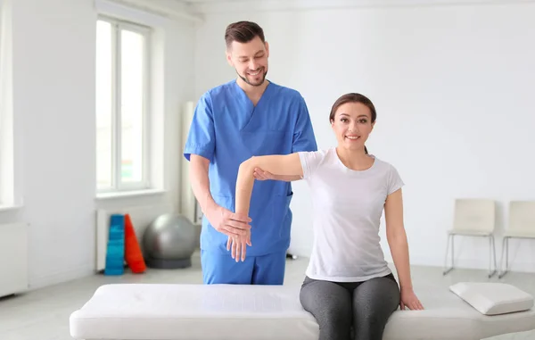 Physiotherapist working with female patient in clinic — Stock Photo, Image