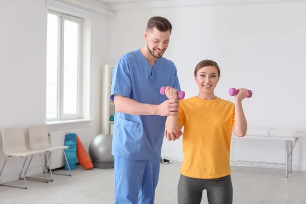 Physiotherapist working with female patient in clinic — Stock Photo, Image