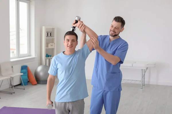 Fisioterapeuta trabalhando com paciente do sexo masculino na clínica — Fotografia de Stock