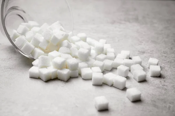 Cubos de azúcar refinados sobre fondo gris —  Fotos de Stock