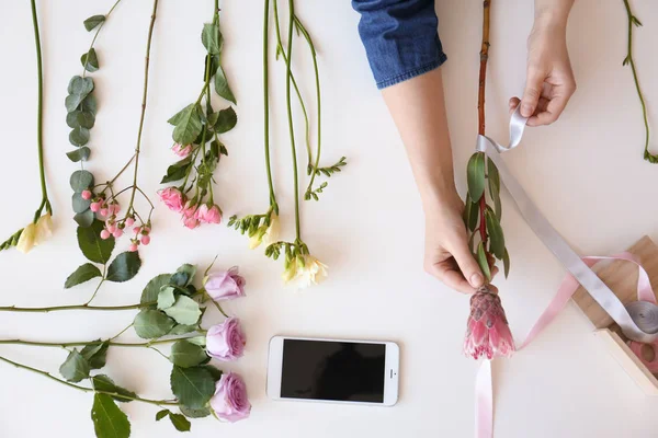 Florista feminino criando belo buquê à mesa, vista superior — Fotografia de Stock