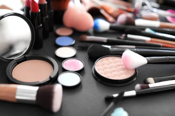 Pędzle do makijażu różnych i produktów kosmetycznych na czarnym tle — Zdjęcie stockowe