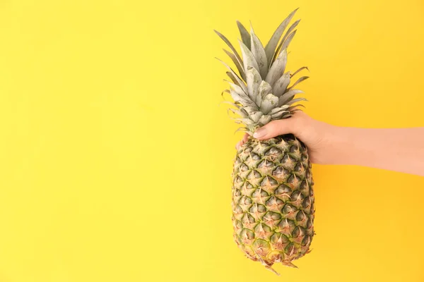 Mujer sosteniendo piña fresca madura sobre fondo de color — Foto de Stock