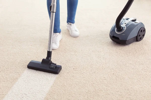 Woman hoovering carpet at home — Stock Photo, Image