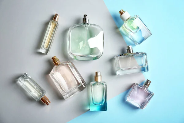 Perfume bottles on colorful background, flat lay