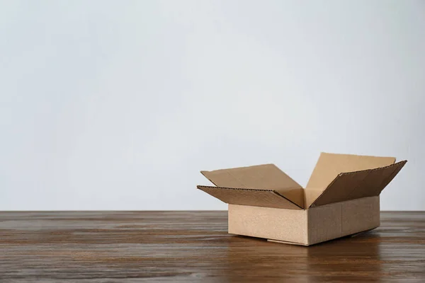 Картонна коробка на дерев'яному столі — стокове фото
