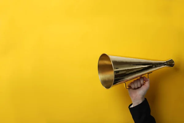 Vrouw met retro megafoon op kleur achtergrond — Stockfoto