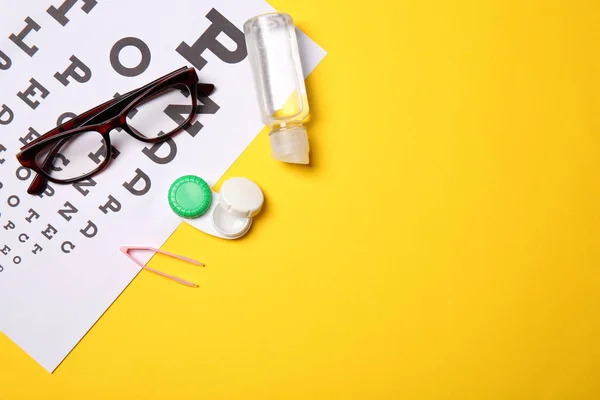 Composición plana con carta de ojos, gafas y accesorios de lentes de contacto sobre fondo de color — Foto de Stock