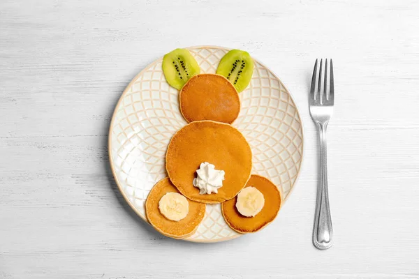 Pancake lucu untuk anak-anak sarapan di meja kayu, pemandangan atas — Stok Foto