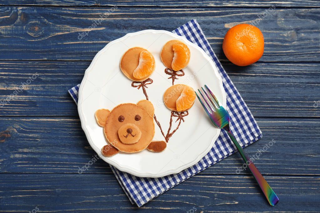 Flat lay composition with pancakes in form of bear holding balloons on wooden background. Creative breakfast ideas for kids