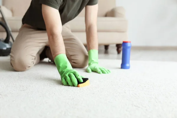 Anak muda membersihkan karpet di rumah — Stok Foto