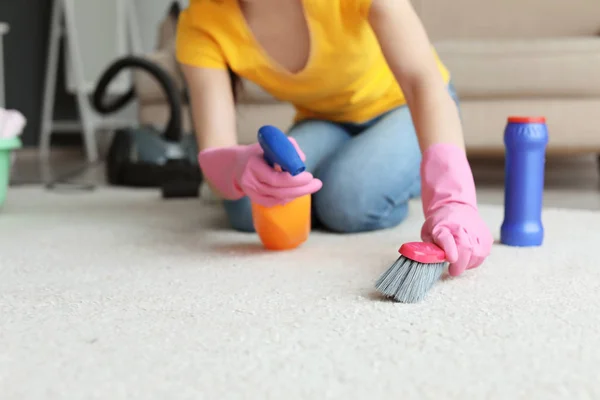 Young woman cleaning carpet at home — Stock Photo, Image