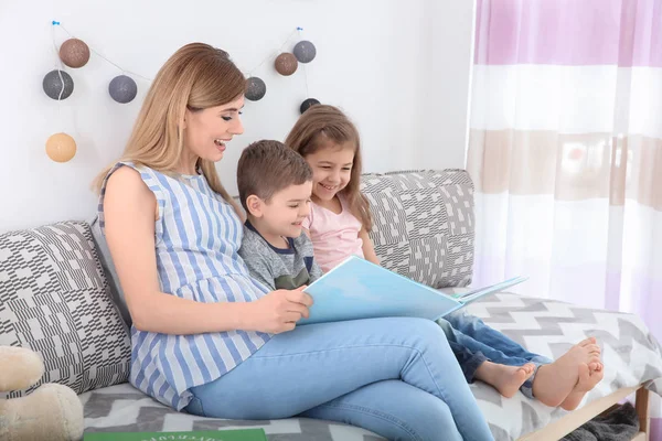 Kindermädchen liest kleinen Kindern zu Hause Buch — Stockfoto