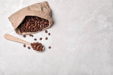 Açık renkli, üstten görünüm üzerinde kahve çekirdekleri ile kaşık ve kağıt çanta