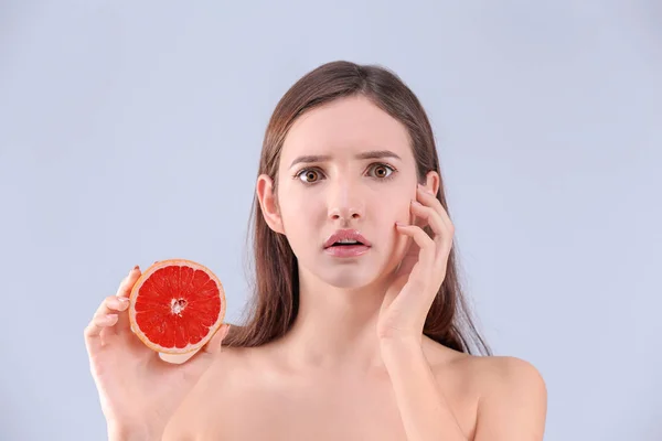 Tienermeisje Met Acne Probleem Bedrijf Grapefruit Tegen Grijze Achtergrond — Stockfoto