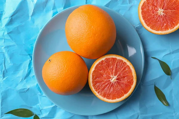 カラー紙の背景に新鮮なおいしいオレンジ プレート — ストック写真