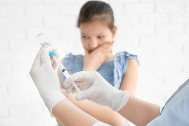 Doktor ilaç ve arka plan üzerinde çocuk ile şırınga doldurma. Aşı günü