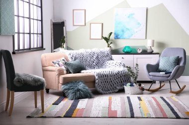 Şık bir oturma odası, rahat bir kanepe ve sallanan bir sandalye.