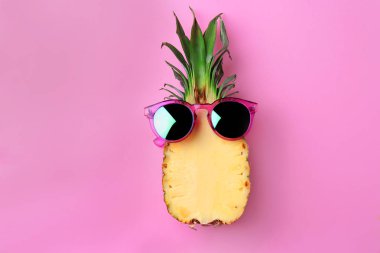 Arka planda güneş gözlüğü olan komik ananas.