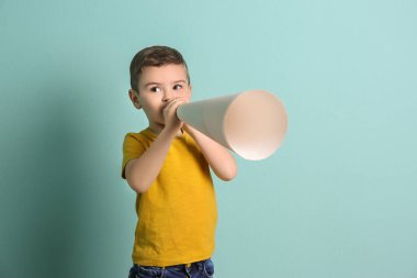 Renk arka plan üzerinde kağıt megafon ile sevimli küçük çocuk