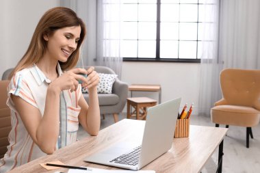 Ev ofis masasında laptop ile çalışan genç kadın