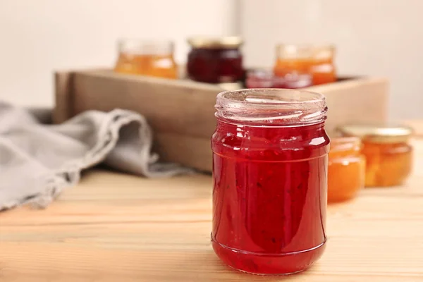 Jar met lekkere zoete jam op houten tafel — Stockfoto