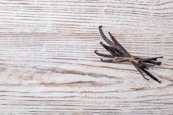 Palos de vainilla sobre fondo de madera — Foto de Stock